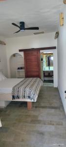 a bedroom with a bed and a ceiling fan at Akarair in Gili Air