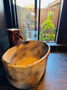 a large wooden tub sitting in front of a window at 藤花楼akagawa 登録文化財 in Osaka