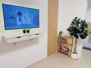 a living room with a television on a wall at Casa Realiyx in Ra-as