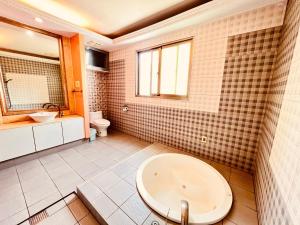 a bathroom with a sink and a tub and a toilet at 富晴汽車旅館Fu Ching Motel in Changhua City
