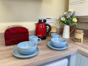 a counter with three blue cups and saucers on it at The Old Coach House in Burythorpe