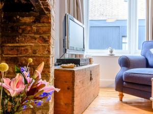 a living room with a tv and a couch and a chair at Anchor Cottage in Whitstable