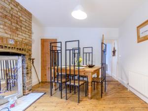 a dining room with a wooden table and chairs at Anchor Cottage in Whitstable