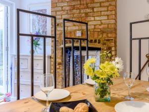 a dining room with a table with glasses and flowers at Anchor Cottage in Whitstable +17 photos