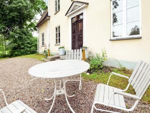 a white table and chairs in front of a house at 11 person holiday home in STORA SUNDBY in Böcklinge