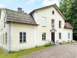 an old white house with a gravel driveway at 11 person holiday home in STORA SUNDBY in Böcklinge