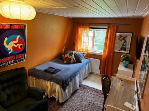 a small bedroom with a bed and a chair at Cozy Room in Uppsala