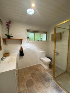a bathroom with a toilet and a sink and a shower at Mornington Peninsula Farmhouse in Main Ridge