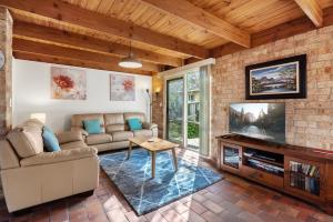 a living room with a couch and a tv at Bungunyah Apartments in Croydon