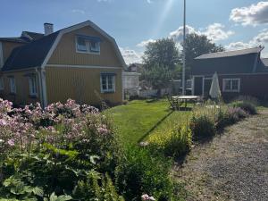 a yard with a house and a table and flowers at Cozy Room in Uppsala