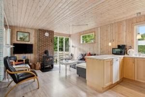a kitchen and living room with wood paneling at Cozy Holiday Home Close To The Beach in Thyholm