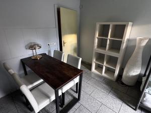 a dining room with a table and chairs and a shelf at Familyroom 6 P Free WiFi Gemeinschaftsbad in Hausbreitenbach