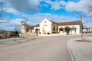 an empty street in front of a white building at La Pause Péronnaise - Maison de ville en coeur de village in Péronne