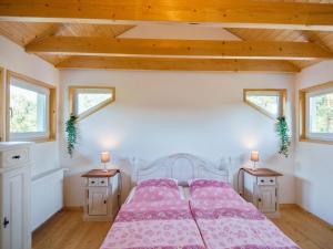 a bedroom with a bed with pink sheets and two tables at Riverside Stay in Sudwinsen in Winsen Aller