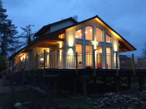 a large wooden house with lights on it at night at Riverside Stay in Sudwinsen in Winsen Aller