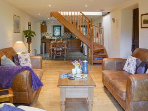 un soggiorno con due divani e un tavolo di Clematis Cottage a Holsworthy