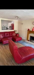 a living room with red furniture and a fireplace at Seaside High Street Homely Hideaway in Dunbar