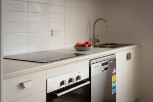 a kitchen with a sink and a bowl of apples at Bay View Retreats- Ocean mist in Dover