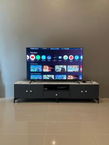 a large flat screen tv sitting on a black entertainment center at 1-bedroom Modern Cozy near Samui Airport in Ko Samui