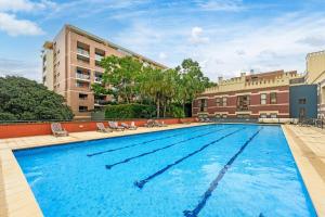 a large swimming pool in front of a building at Redfern 2Br Near CBD Shopping Center with Pool & Gym in Sydney