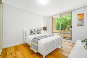 a white bedroom with a bed and a window at Redfern 2Br Near CBD Shopping Center with Pool & Gym in Sydney +18 photos