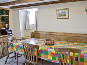 a dining room with a colorful table and chairs at Pillar Box Cottage in Tintagel