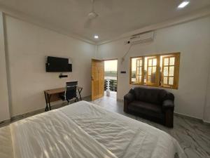 a bedroom with a bed and a chair and a desk at AKR Rooms in Mannar