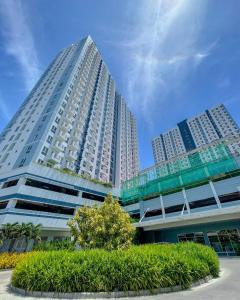 a tall white building with a tree in front of it at Sky Pad Avida Abreeza Davao in Davao City
