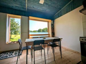 a kitchen with a table and chairs and a window at Útulný apartmán Vážka u Pastvinské přehrady v Orlických horách in Nekoř