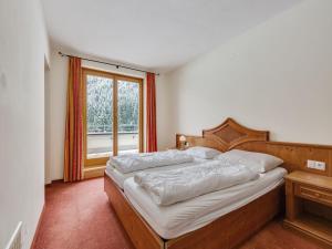 a bedroom with a large bed and a window at Chalet in Saalbach near Ski Lift in Saalbach-Hinterglemm