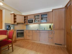 a large kitchen with wooden cabinets and a table at Chalet in Saalbach near Ski Lift in Saalbach-Hinterglemm