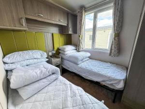 a room with two beds and a window at Stunning 6 Berth Caravan, Close To The Beach In Suffolk Ref 68067Cr in Lowestoft +16 photos
