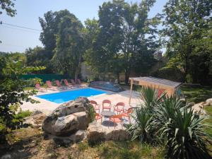 a pool with chairs and a table and a rock at Lou Cantou sur Lunain in Paley