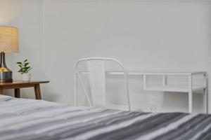 a white bunk bed next to a table and a lamp at Bloomfield Pittsburgh E Stylish and Cozy Private Bedroom, Shared Bathroom, with Free Parking in Pittsburgh