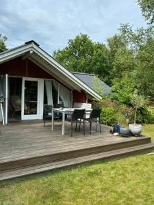a wooden deck with a table and chairs on it at Family Cabin By The Calm Waters Of Limfjord in Højslev