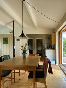 une table de salle à manger avec un vase de fleurs dessus dans l'établissement Family House By Roskilde Fjord And North Forest, à Jægerspris