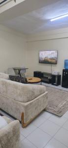 a living room with a couch and a painting on the wall at The Unwind Spot Kitengela in Kitengela 
