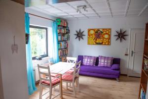 a living room with a table and a purple couch at Campo Allegre Duplex Ferienwohnung in Windeck +22 photos