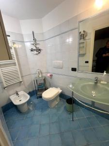 ein Badezimmer mit Waschbecken, Toilette und Spiegel in der Unterkunft Casa Borgo prino in Imperia