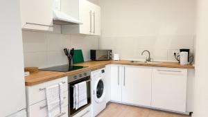 a kitchen with white cabinets and a washer and dryer at Monteurwohnungen mit TV, Internet, Parkplatz, Waschmaschine, Küche, Balkon, Restaurants und Supermarkt in Halle an der Saale