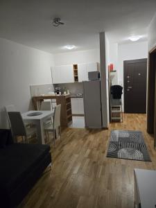 a kitchen and a living room with a table and a refrigerator at Central Lux in Čačak +9 photos