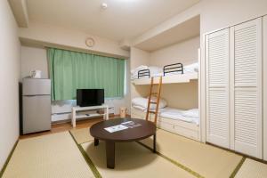 a small room with bunk beds and a table at Angel Resort Yuzawa in Yuzawa