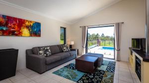 a living room with a couch and a tv at 'Mandalay Villa 2' in Paxton