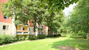 an apartment building with trees and a grass yard at Monteurwohnungen mit TV, Internet, Parkplatz, Waschmaschine, Küche, Balkon, Restaurants und Supermarkt in Halle an der Saale