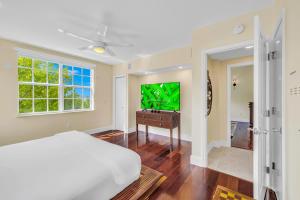 a bedroom with a bed and a flat screen tv at Ocean View Penthouse Retreat amenities: tennis court heated Pool Vista Key Two in Islamorada +21 photos