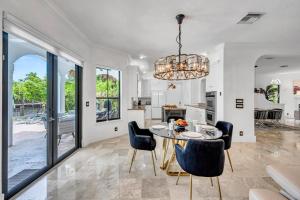 フォート・ローダーデールにあるVenice of America Heated Pool Canal View Access Isle Key VlLLASのテーブルと椅子のあるキッチンとダイニングルーム