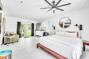 a white bedroom with a bed and a mirror at Waterfront Oasis Cascading Pool Views Centrally located Heated Pool Cascade KeyResidences in Fort Lauderdale +38 photos