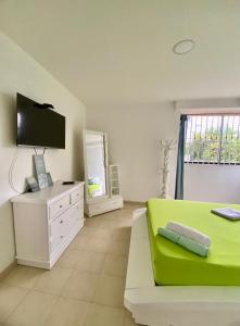 a living room with a green couch and a tv at Apartamento Boutique Cartagena Plaza de Toros in Cartagena de Indias