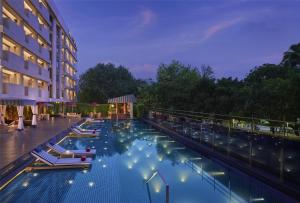 a hotel swimming pool with chairs and a building at Hyatt Centric Sector17 Chandigarh in Chandīgarh