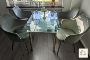 a dining room table with four chairs and a glass table at Einzigartige Ferienwohnung -hier im jetzt- in Felsberg